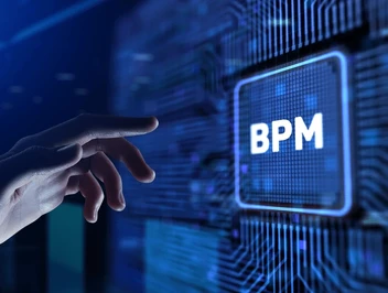 Dłoń wskazująca na nowoczesny, świecący układ scalony (procesor) z napisem BPM, symbolizujący technologię i system zarządzania procesami biznesowymi.