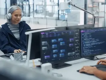 Pracownicy przy komputerach z wieloma monitorami - szybkie projektowanie i rozwój aplikacji w technologii low-code
