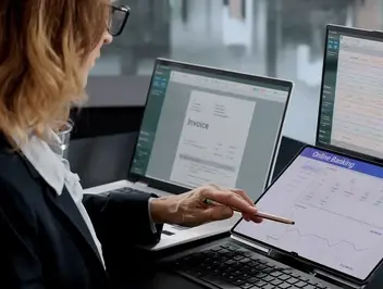 Kobieta analizuje dane na kilku laptopach - wizualizacja optymalizacji kosztów i zarządzania dokumentami w elektronicznym obiegu w firmie