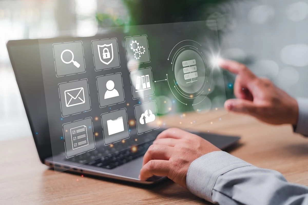 Dłonie na laptopie i wirtualny interfejs z ikonami dotyczącymi integracji z ksef