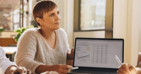 Kobieta wskazuje na ekran laptopa tłumacząc czym jest process mining
