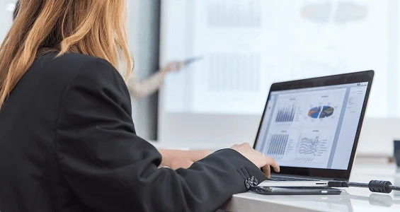 Kobieta przed laptopem analizuje czym process mining różni się od audytu lub ankiety