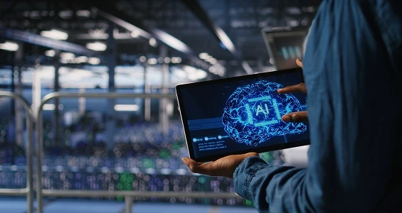 Wdrożenie sztucznej inteligencji (AI) w firmie – pracownik z tabletem wyświetlającym model mózgu AI