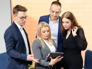 Zespół urzędników administracji publicznej analizuje raport budżetowy na tablecie
