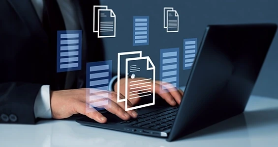 Osoba pracująca na laptopie z cyfrowymi ikonami dokumentów symbolizującymi system DMS